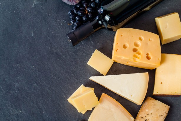 43576556 - different types of cheeses, red wine, grapes and figa on black board, top view