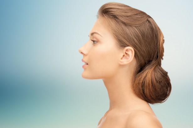 health, people, plastic surgery and beauty concept - beautiful young woman face over blue background