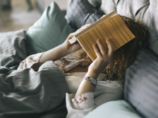 Дівчина із книгою у ліжку фото
